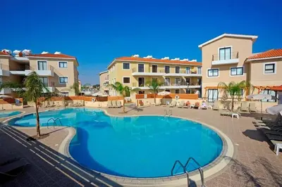 a swimming pool in front of some apartment buildings at Anemone - walk to the beach in Paralimni
