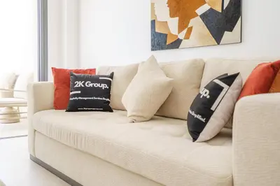 a white couch with pillows on it in a living room at Kalamon Luxury Suite 105 w Pool & Gym in Livadhia
