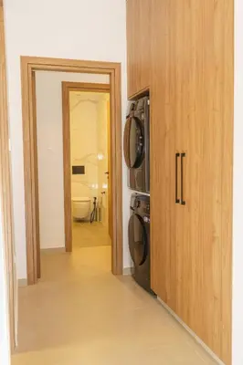 a kitchen with a microwave and a door to a bathroom at Kalamon Luxury Suite 105 w Pool & Gym in Livadhia