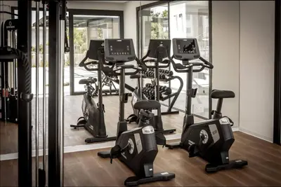 a gym with a row of treadmills and exercise bikes at Kalamon Luxury Suite 105 w Pool & Gym in Livadhia