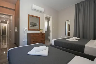 a hotel room with two beds and a bathroom at Villa Evergreen - 3bed Bungalow large pool in Protaras