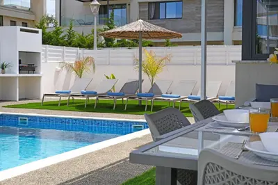a patio with a table and chairs next to a pool at Villa Violeta - 3bed Bungalow large pool in Protaras