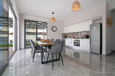 a kitchen with a table and chairs and a refrigerator at Villa Violeta - 3bed Bungalow large pool in Protaras
