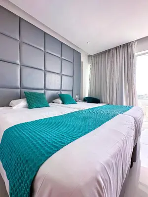 a large bed with a blue headboard in a bedroom at Silver Sands Beach Hotel in Protaras