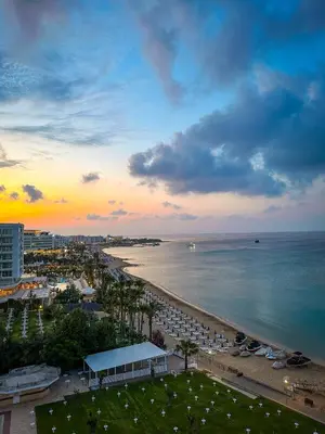 a view of a beach and the ocean at sunset at Silver Sands Beach Hotel in Protaras