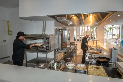 two men standing in a kitchen preparing food at Papantonia Hotel in Protaras
