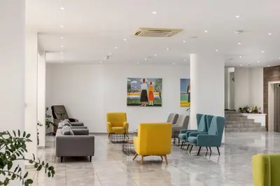 a lobby with chairs and a painting on the wall at Papantonia Hotel in Protaras
