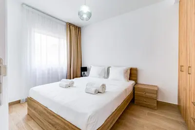 a bedroom with a large white bed with towels on it at Aeolis Court Apartment by Ezoria Villas in Limassol