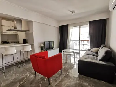 a living room with a couch and a red chair at Naxou Modern Residence By Staycom in Nicosia