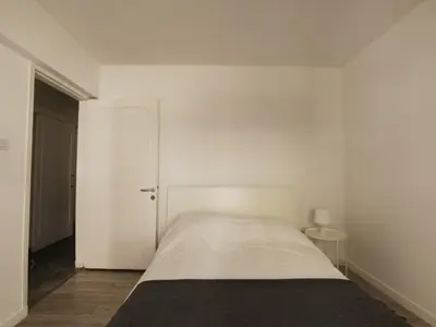 a white bedroom with a bed and a door at Naxou Modern Residence By Staycom in Nicosia