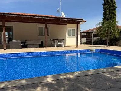 a swimming pool in front of a house at Sunset Villa Agia Thekla in Ayia Napa
