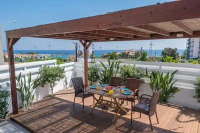 a patio with a table and chairs on a balcony at Narcissos Bay View Villa in Protaras
