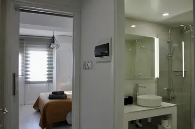 a bathroom with a sink and a shower and a bed at Nicosia Central Suites in Nicosia