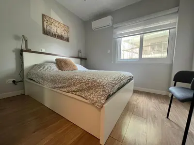 a bedroom with a bed and a window and a chair at Cozy City Nest, Heart of Limassol in Limassol