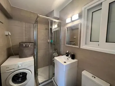 a small bathroom with a washing machine and a sink at Cozy City Nest, Heart of Limassol in Limassol