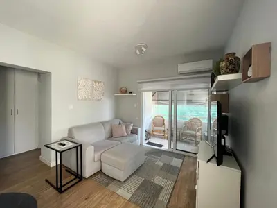 a living room with a white couch and a table at Cozy City Nest, Heart of Limassol in Limassol