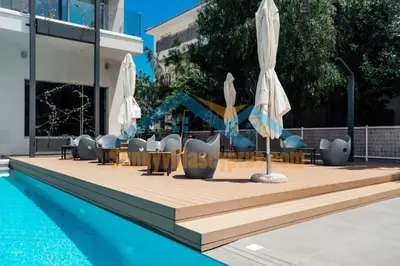 a pool with umbrellas and tables and chairs next to a pool at SunnyVillas Suite Mythical GYM Swimming Pool S21 in Paralimni