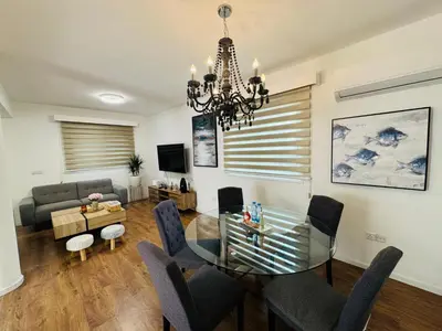 a living room with a glass table and chairs at Sea side House in Voroklini