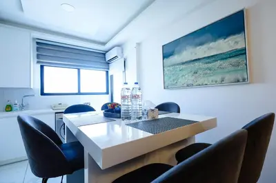 a dining room with a white table and chairs at Bloom of Luxury in Limassol