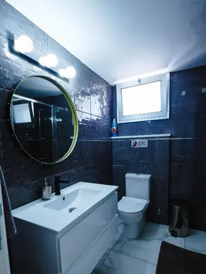 a bathroom with a sink and a toilet and a mirror at Bloom of Luxury in Limassol