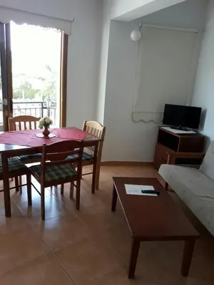 a living room with a table and a couch at Yialos Apartments in Pissouri