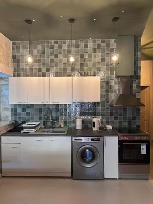 a kitchen with white cabinets and a washing machine at Mavrommati Luxury Residence no1 in Limassol