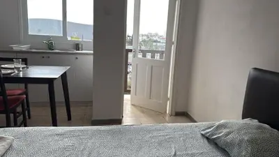 a room with a table and a kitchen with a table and a window at Sun Shine Studio With Balcony in Larnaka