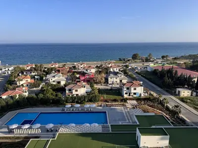 an aerial view of a resort with a swimming pool and the ocean at A peaceful apartment with sea views in Aglantzia