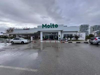 a mobiloco gas station with cars parked in a parking lot at A peaceful apartment with sea views in Aglantzia