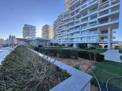 a large apartment building with a garden in front of it at A peaceful apartment with sea views in Aglantzia