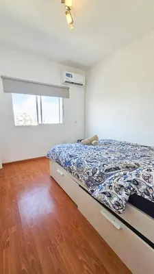 a bedroom with a bed and a wooden floor at Central Rooms, 500m to Larnaca Marina in Larnaka