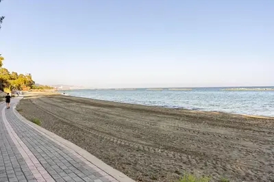 a person walking on a beach next to the water at Beachfront Luxury Apartment in Limassol