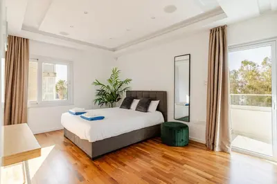 a bedroom with a bed and a large window at Beachfront Luxury Apartment in Limassol