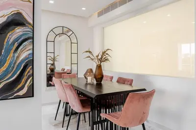 a dining room with a table and pink chairs at Beachfront Luxury Apartment in Limassol