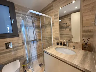 a bathroom with a sink and a glass shower at Luxury Seaview Escape 3bd in Limassol Skyscraper in Limassol