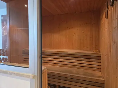 a sauna with wooden walls and a glass door at Luxury Seaview Escape 3bd in Limassol Skyscraper in Limassol