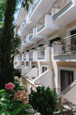 an apartment building with white balconies and flowers at Pendeli Resort in Platres