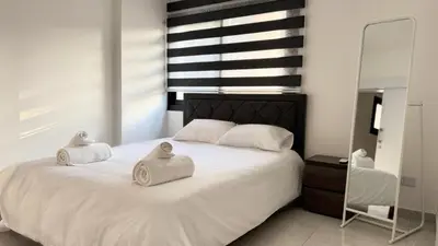 a bedroom with a white bed with towels on it at Modern One-Bedroom Suite with Balcony in Central Nicosia in Nicosia