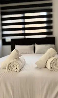 a white bed with two towels on top of it at Modern One-Bedroom Suite with Balcony in Central Nicosia in Nicosia