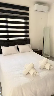 a white bed with two towels on top of it at Modern One-Bedroom Suite with Balcony in Central Nicosia in Nicosia