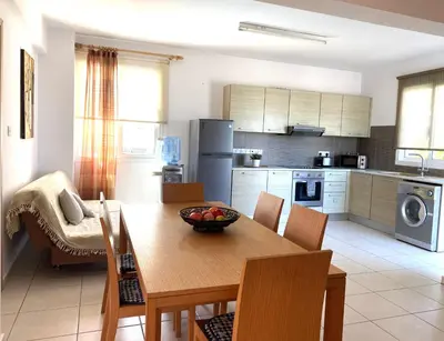 a kitchen with a wooden table with a bowl of fruit on it at Athena Holiday Villa DPS01 in Protaras