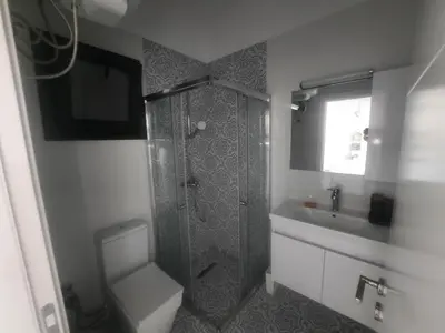 a bathroom with a shower and a toilet and a sink at CAESAR RESORT İSKELE Long Beach in Vrysoules