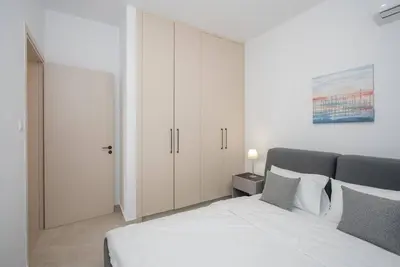 a bedroom with a white bed and white cabinets at Kalamon Luxury Suite 202 w Pool and Gym in Larnaka