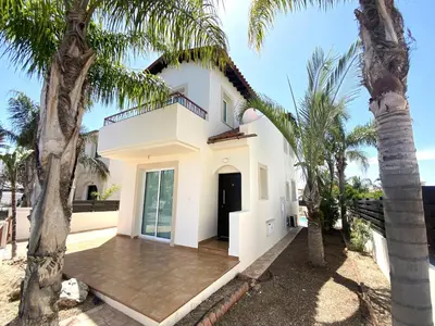 a white house with palm trees in front of it at Artemis Holiday Villa DPS09 with pool in Paralimni
