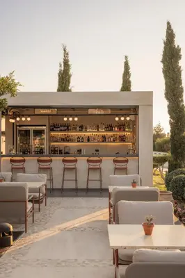 a restaurant with tables and chairs and a bar at kolektif suites in Kérynia