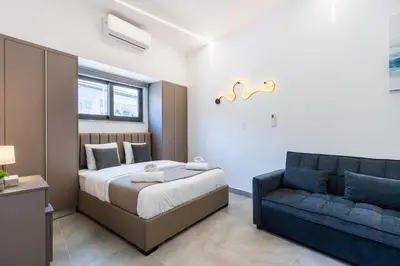 a bedroom with a bed and a blue couch at Le Bandit Studio in Larnaka