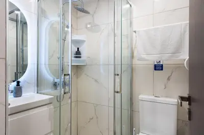a bathroom with a shower and a toilet and a sink at Starlight Studio in Larnaka