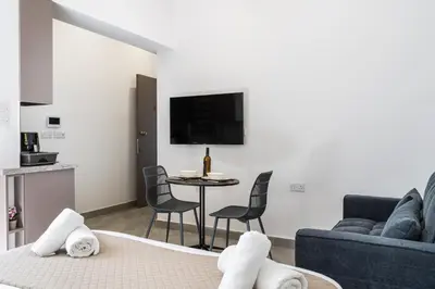 a living room with a couch and a table with towels at Starlight Studio in Larnaka