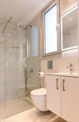 a bathroom with a toilet and a glass shower at Nissinest Luxury Villas in Ayia Napa
