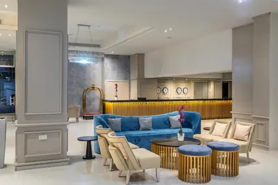a living room with a blue couch and a table at Constantinos the Great Beach Hotel in Protaras